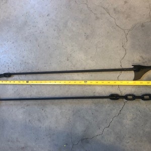 May include: Two black metal fence post toppers with a chain link design. The toppers are approximately 48 inches long.