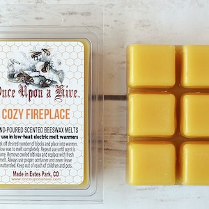 May include: Six yellow beeswax melts in a clear plastic container. The container has a label that reads "Once Upon a Hive. Cozy Fireplace" and includes instructions for use in low-heat electric melt warmers.