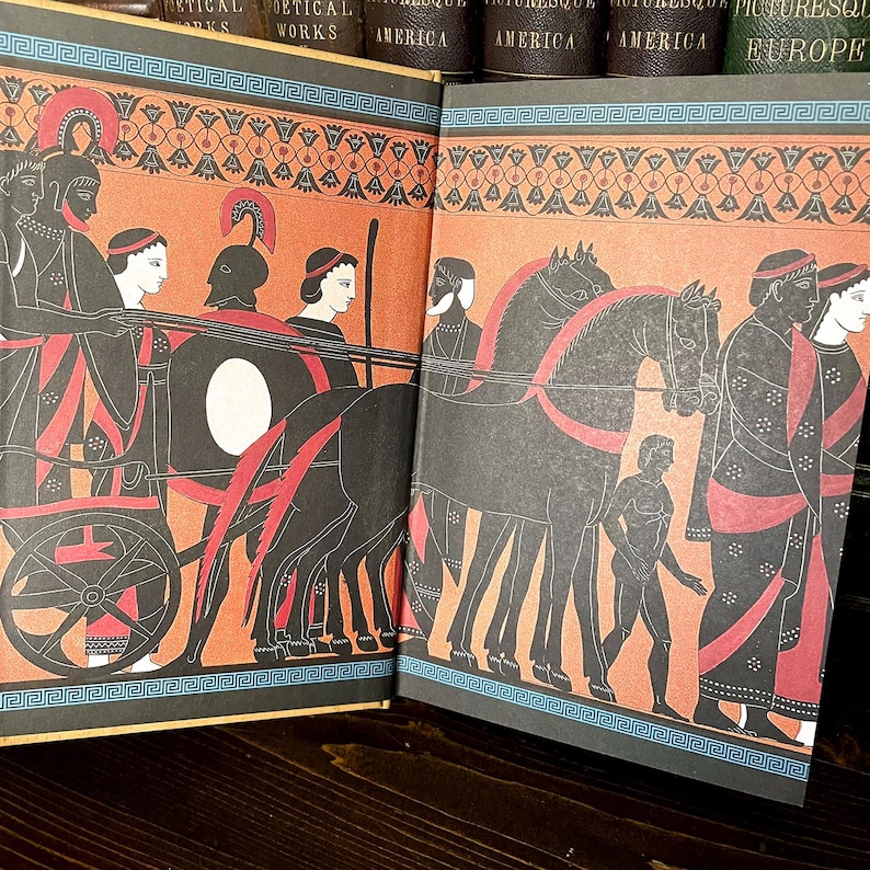 May include: A double-page spread from a book with illustrations of ancient Greek scenes. The artwork uses black, red, and orange, with a decorative border. The book is open on a dark wooden surface.