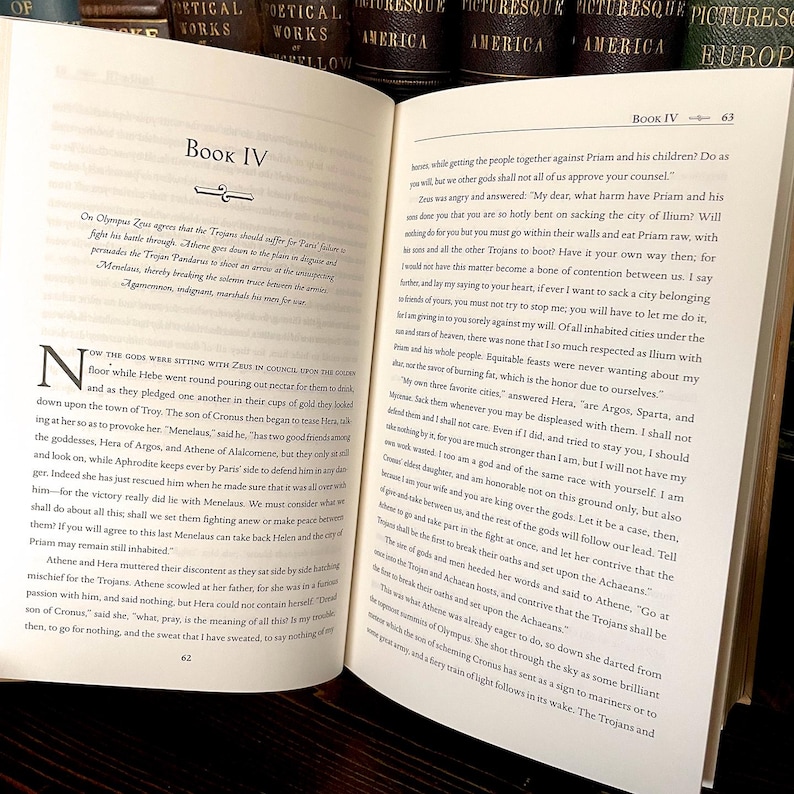 May include: An open book with text on aged paper. The pages display text from a classic work, with chapter headings and page numbers visible. The book is likely a historical or literary text, with a focus on the written word.