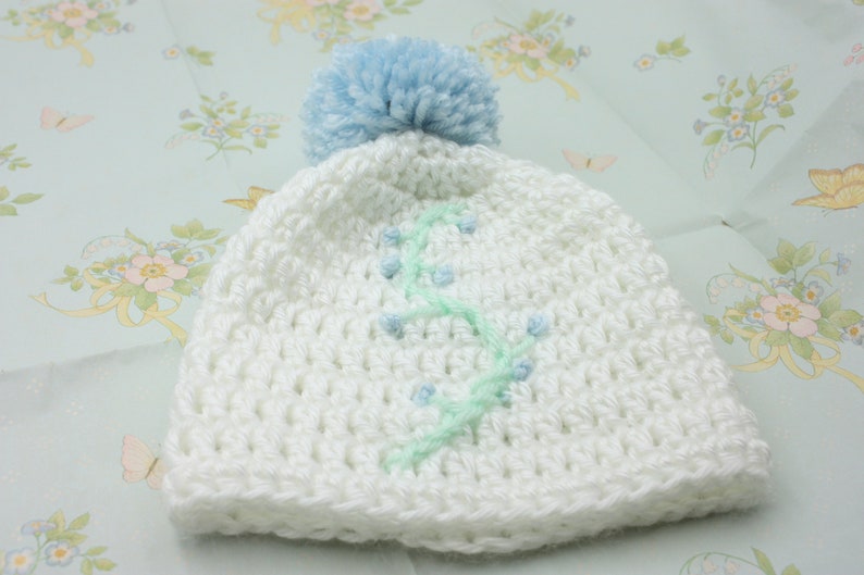 White Baby Hat With Blue Floral Embroidery and Blue Pompom Newborn Hat
