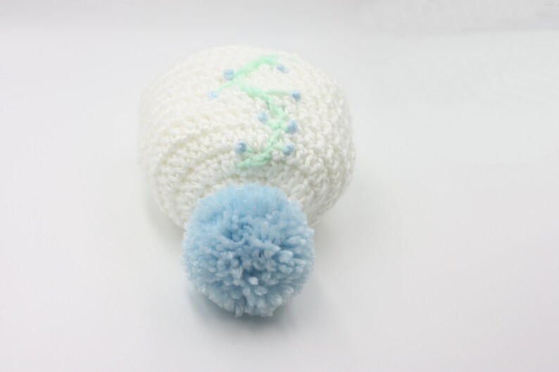 White Baby Hat With Blue Floral Embroidery and Blue Pompom Newborn Hat