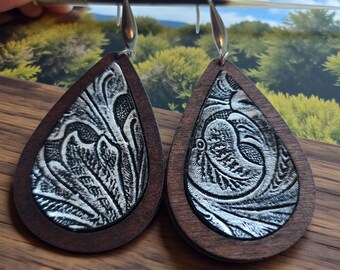 Droppformade örhängen i trä med konstgjord metallisk blommönster i läder