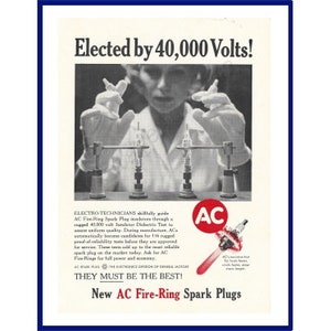 May include: A vintage black and white advertisement for AC Fire-Ring Spark Plugs. The ad shows a person in a lab coat holding two spark plugs in front of a device that is generating 40,000 volts of electricity. The text "Elected by 40,000 Volts!" is at the top of the ad. The text "They must be the best!" is below the image. The text "New AC Fire-Ring Spark Plugs" is at the bottom of the ad.