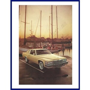 May include: A yellow Cadillac Coupe DeVille parked in front of a marina with sailboats in the background. The car is parked on a paved surface and the sun is setting in the background.