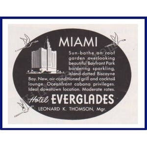 May include: Vintage advertisement for the Hotel Everglades in Miami. The black and white image features the hotel name, location, and amenities within an oval frame, with decorative birds. Text includes "Sun-bathe on roof garden overlooking beautiful Bayfront Park."