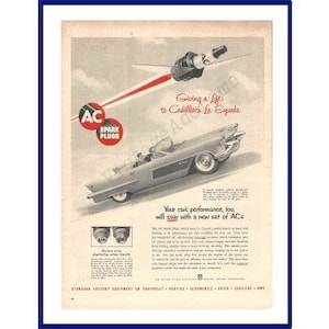 May include: A black and white vintage advertisement for AC Spark Plugs featuring a silver Cadillac convertible driving down a road. The ad text reads "Giving a lift to Cadillacs in Espanola" and "Your car performance, too, will soar with a new set of ACs."
