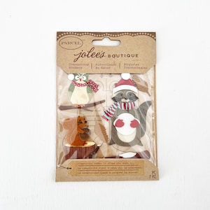 May include: A set of 7 dimensional stickers featuring woodland animals in wintery attire. The stickers are on a brown card with the text "jolee's BOUTIQUE" and "Creativity comes to those who seek it."