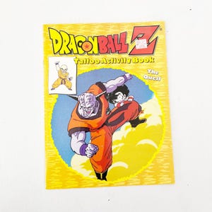 May include: A yellow Dragon Ball Z Tattoo Activity Book titled The Quest. The cover features a large illustration of a purple-skinned character with horns and a smaller character in orange clothing, plus a small inset image of a bald character.