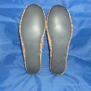 May include: A pair of black and brown leopard print slippers with black soles.
