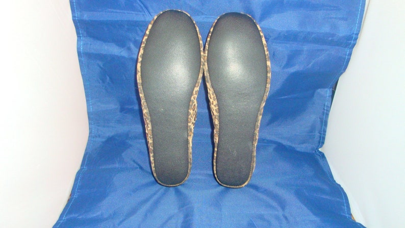 May include: A pair of black and brown leopard print slippers with black soles.