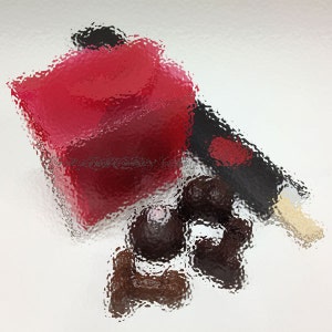 May include: A red box with a black and white striped lid, surrounded by dark chocolate truffles.