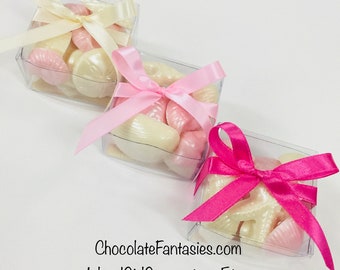 May include: Three clear boxes filled with white and pink chocolate seashells and starfish. The boxes are tied with pink and ivory satin ribbon bows. ChocolateFantasies.com IslandGirlGourmet on Etsy
