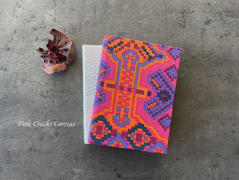 May include: Two notebooks, one with a white cover and the other with a pink, orange, and purple geometric pattern. The text "Pink Checks Canvas" is visible on the bottom left of the image.
