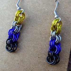 May include: A pair of dangle earrings with a chainmail design in black, purple, silver, and yellow colours.
