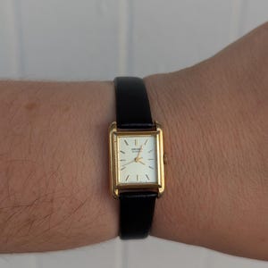 Vintage SEIKO Gold Tone Tank Quartz Watch with New Black Leather Band and New Battery. Best fits 6.5” wrist or smaller.