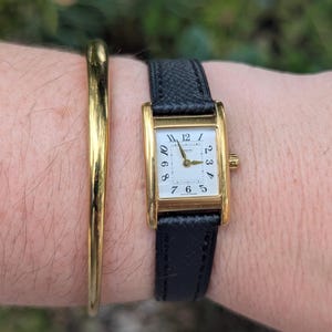 Vintage COACH Gold Tone Tank Quartz Watch with New Black Leather Band and New Battery. Best fits 7” wrist or smaller.