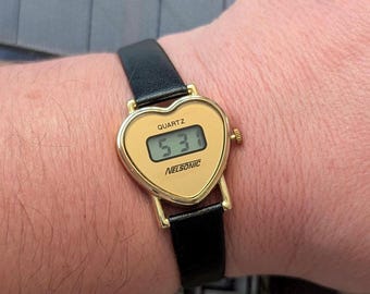 Vintage NELSONIC Gold Tone Heart Shape Digital Quartz Watch with New Black Leather Band and New Battery. Best fits 7” wrist or smaller.