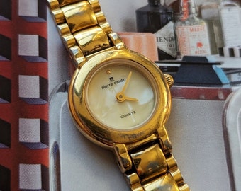 Vintage Gold Pierre Cardin Watch Featuring Pearl Face with New Battery. Best fits 6.5” wrist or smaller.