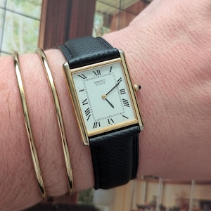 Vintage SEIKO Gold Tone Tank Quartz Watch with New Black Leather Band and New Battery.  Best fits 7.5” wrist or smaller.
