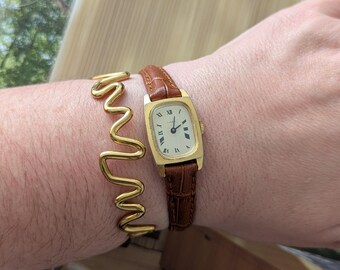 Vintage TIMEX Gold Tone Winding Watch with New Brown Leather Band. Best fits 7” wrist or smaller.