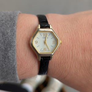 vintage Carriage by TIMEX montre à quartz hexagonale dorée avec nouveau bracelet en cuir noir et nouvelle pile. Convient parfaitement aux poignets jusqu'à 6,75 pouces.