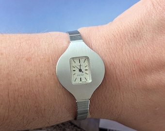 BROKEN Vintage TIMEX Silver Tone Quartz Watch with White Face. Best fits 8” wrist or smaller.