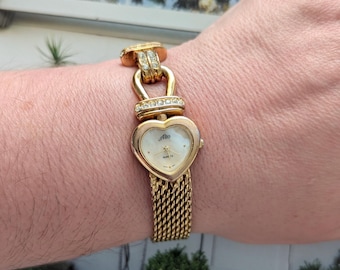 Vintage ALTO Gold Tone Quartz Watch with Heart Bezel, Crystal Detail, pearlescent face and New Battery. Best fits 7” wrist or smaller.