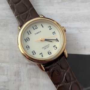 ヴィンテージのTIMEXゴールドトーンクォーツウォッチ。新品ブラウン