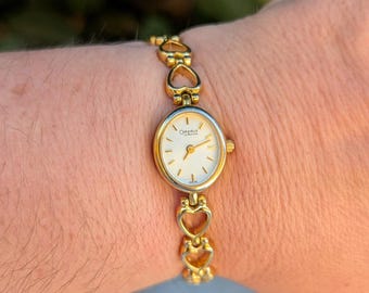 Vintage BULOVA Gold Tone Quartz Watch with Heart Detail Band and New Battery. Best fits 6.5” wrist or smaller.