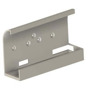 Puede incluir: Un soporte metálico gris claro con una base rectangular y un borde superior curvado. El soporte tiene varios orificios para tornillos y un recorte rectangular. El diseño es simple y funcional.