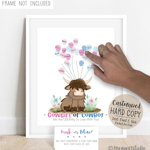 May include: A white print featuring a brown Highland cow illustration with pink and blue balloon-shaped fingerprints. Text reads: Cowgirl or Cowboy, We Are UDDERly In Love With You! Includes a small instruction card: Pink or Blue? Add your fingerprint.