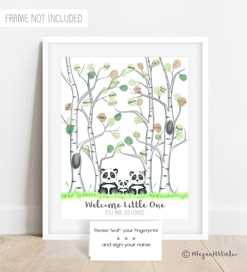 May include: A framed print featuring a panda family under birch trees with green and brown leaves. The text "Welcome Little One, You Are So Loved" is displayed. A card below invites guests to leave fingerprints and sign their names.