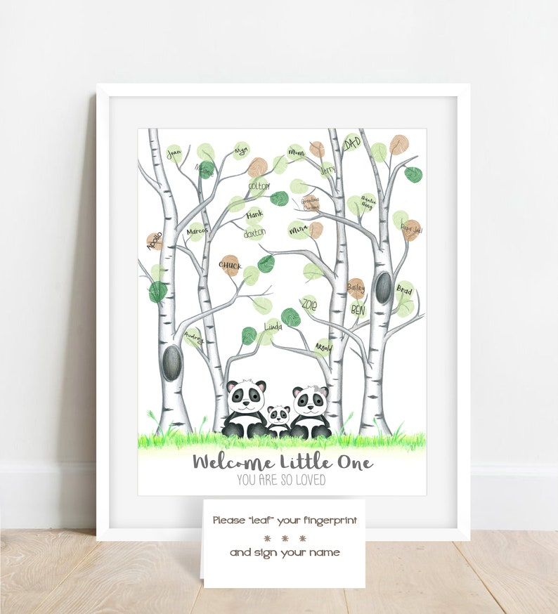 May include: A framed print featuring a whimsical illustration of a family of pandas beneath birch trees with green and brown leaves. The text "Welcome Little One, You Are So Loved" is displayed. A card encourages guests to leave fingerprints.