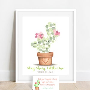 image of a sample of a completed fingerprint cactus shown with green and red fingerprints filling in a cactus outline, shown displayed in a frame with an instruction card, meganhstudio