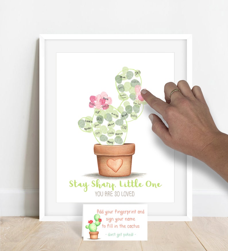 Image of a personalized fingerprint cactus showing a guest at a baby shower adding a fingerprint with green stamp pad ink to fill in the outline of a cactus, fingerprint guestbook alternative for a desert themed baby shower or birthday party