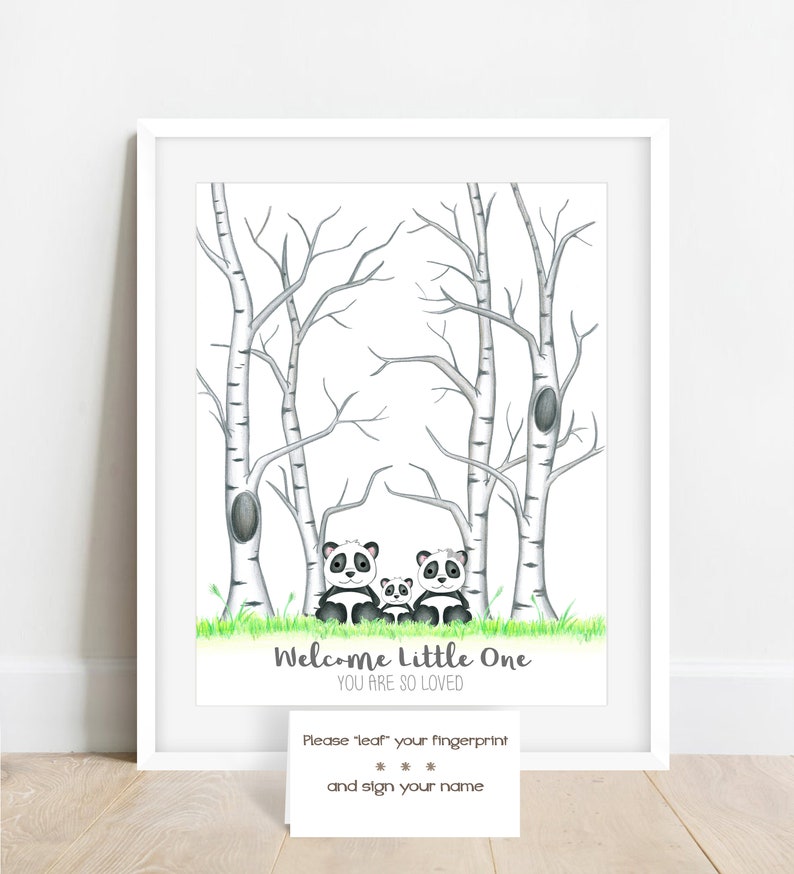 May include: A framed print featuring a watercolor illustration of a panda family in a forest setting. The artwork includes birch trees, green grass, and the text "Welcome Little One, You Are So Loved." A small card below invites guests to leave fingerprints.
