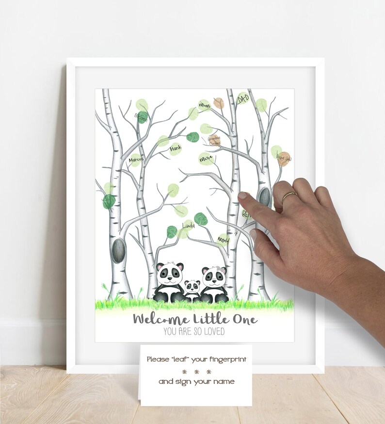 May include: A framed print featuring a whimsical illustration of birch trees with green leaf accents. Below the trees are three panda bears. The text "Welcome Little One, You Are So Loved" is displayed. A card below reads "Please 'leaf' your fingerprint and sign your name."