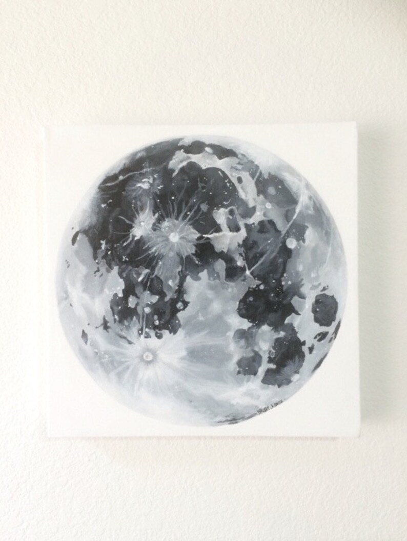 Pode incluir: Uma pintura em preto e branco de uma lua cheia em uma tela branca. A lua &eacute; pintada em detalhes, mostrando suas crateras e caracter&iacute;sticas da superf&iacute;cie. A assinatura do artista &eacute; vis&iacute;vel no canto inferior direito.