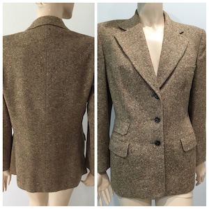May include: A brown tweed blazer with a notched collar, three buttons, and flap pockets.