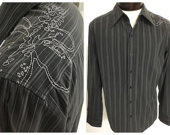 May include: A black and white striped long-sleeve button-up shirt with a white embroidered design on the left shoulder.