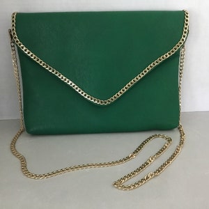May include: A green leather clutch with a gold chain strap. The clutch has a flap closure and a gold chain trim.