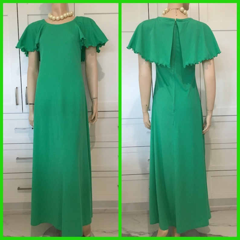 May include: A long, green maxi dress with a ruffled collar and short sleeves. The dress has a back zipper and a fitted bodice.