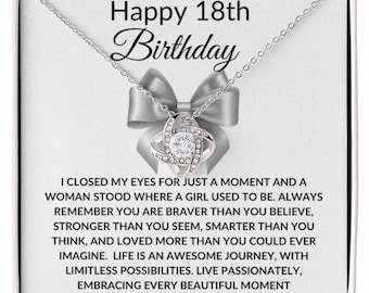 May include: A silver necklace with a clear crystal pendant in a gift box. The box has a white background with the text "Happy 18th Birthday" and a message about being brave, strong, and loved.
