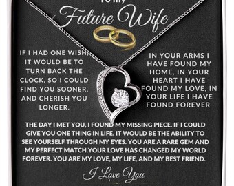 May include: A silver-toned necklace with a heart-shaped pendant, encrusted with small clear stones and a central, larger clear stone. The pendant hangs from a delicate chain. The box reads "To my Future Wife" and includes the text "I Love You".