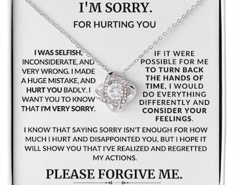 May include: A silver necklace with a knot pendant and a white card with the text "I'm sorry. For hurting you. I was selfish, inconsiderate, and very wrong. I made a huge mistake, and hurt you badly. I want you to know that I'm very sorry. If it were possible for me to turn back the hands of time, I would do everything differently and consider your feelings. I know that saying sorry isn't enough for how much I hurt and disappointed you, but I hope it will show you that I've realized and regretted my actions. Please forgive me."