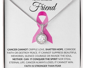 May include: A silver necklace with a pink ribbon charm and a clear crystal pendant. The necklace comes in a box with the message "To my strong friend" and a quote about faith and cancer.