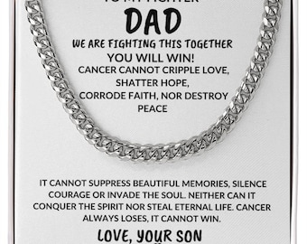 May include: A white box with a silver chain necklace inside. The box has a message for a father fighting cancer that reads "To my fighter Dad, We are fighting this together, You will win! Cancer cannot cripple love, shatter hope, corrode faith, nor destroy peace. It cannot suppress beautiful memories, silence courage or invade the soul. Neither can it conquer the spirit nor steal eternal life. Cancer always loses, it cannot win. Love, your son."