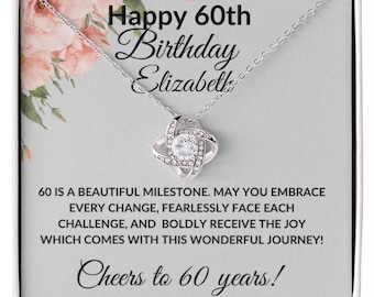 May include: A silver necklace with a sparkling pendant is displayed in a gift box. The box has text that reads "Happy 60th Birthday Elizabeth" and "Cheers to 60 years!" with a floral design.