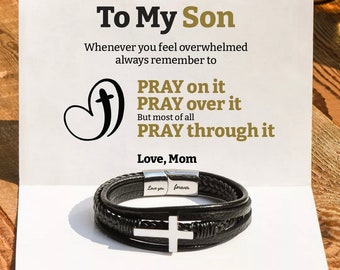 May include: A card with the message "To My Son" and the text "Whenever you feel overwhelmed always remember to PRAY on it PRAY over it But most of all PRAY through it Love, Mom" with a black leather bracelet with a silver cross charm and the words "Love you forever" engraved on the clasp.